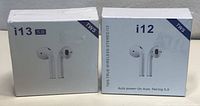 Photo showing two retail boxes of wireless earbuds, one i13 5.0 TWS and one i12 TWS with auto power-on and pairing 5.0 Bluetooth.