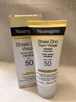 Photo showing a tube of Neutrogena Sheer Zinc Face mineral sunscreen SPF 50 alongside its box. Information on packaging visible including brand, product name, SPF rating, size, and French translation.