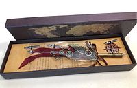 Calligraphy pen set with steampunk elements including gears, feathers, and compass.