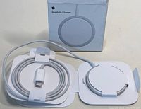 Photo of Apple MagSafe Charger in open box showing coiled white USB-C cable attached to circular charger pad.
