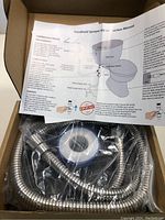 Photo of the bidet kit in box with components and folded installation guide visible.
