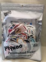 Front view of sealed package containing a large amount of mixed stickers with visible colorful designs inside the clear plastic bag.
