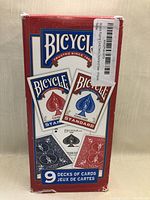 Photo showing box containing 9 decks of Bicycle Standard Playing Cards in red and blue backs, sealed in shrink wrap with barcode sticker.