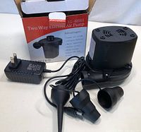 Two Way Electric Air Pump XG-668A with power adapter and three nozzle attachments, showing the pump and packaging box.