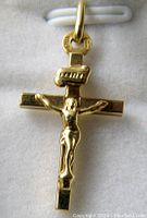 Front view of 10K gold crucifix pendant showing detailed figure of Jesus Christ and INRI plaque on cross.