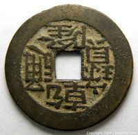 Close-up view of obverse side of the coin showing four Chinese characters around a square hole.