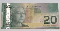 Front side of 2004 Canadian $20 banknote showing Queen Elizabeth II and holographic security strip.