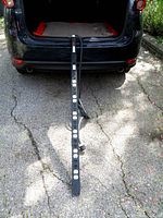 Full length of the industrial power strip placed on ground beside car, showing multiple electrical outlets and power cord.