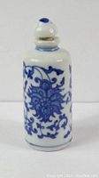 Front view of vintage Chinese porcelain snuff bottle showing blue floral pattern and stopper