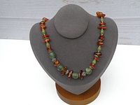 Full front view of the necklace on grey display stand showing bead details and overall length.