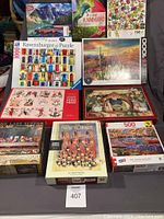 Full view of 10 assorted jigsaw puzzles arranged in rows showing box artwork and piece counts.