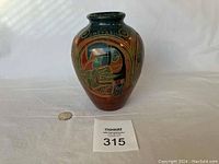 Full view of handmade painted clay vase from Costa Rica with visible toucan painting and 'Costa Rica' inscription near rim, placed next to a quarter for size reference.