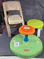 Shows the Playskool Sit-n-Spin toy, the Step 2 folding chair, and the small green table/stool arranged on a fabric backdrop.
