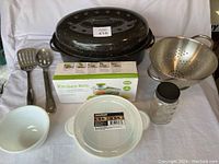 Full view of lot showing broiler, utensils, ceramic bowl, colander, storage jar and plastic container, and unopened Kitchen Rite box