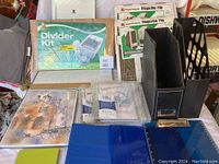 Photo showing the Divider Kit in original packaging along with black Magnetic magazine files, blue binder, stationery items, and other office organizers arranged on a table.