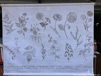 Full view of the off-white woven canvas wall art showing multiple detailed botanical drawings of herbs with labels beneath each illustration.