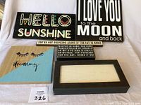 Photo of all six wooden signs arranged on a flat surface, showing various positive and humorous messages and one blank canvas sign.