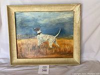 Framed oil painting of a white and brown spotted dog standing in grass with blue sky background