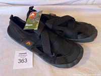 Pair of black Ozark Trail beach shoes with tags, size 11, shown from left angled view to display strap design and overall style.