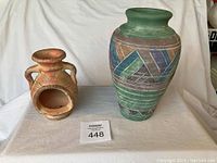 Photo of both the pottery vase with geometric patterns and rustic candle holder together