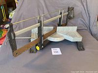 Overall view of Stanley compound miter box with saw attached, showing the frame and rusty blade.