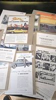 Top-down view of several vintage car advertisements including Chrysler, De Soto, and Plymouth models, showing condition and text content.