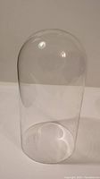 Photo showing the full height and curved shape of the clear glass dome upright on a flat surface.