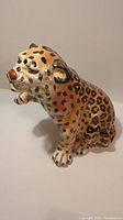 Side angle showing the cheetah's raised paw and detailed paintwork on spots and face.