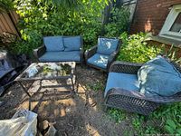 Overall view of the four-piece patio set under foliage on ground