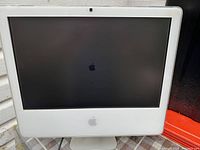 Front view of the 22-inch Apple iMac desktop computer showing the screen powered on with Apple logo visible.