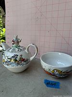 Photo showing both the Alice in Wonderland teapot with White Rabbit lid and matching cup.