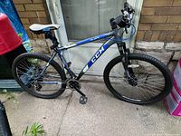 Full side view of CCM Slope mountain bike showing aluminum frame with blue and black paint.