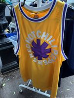 Front view of yellow mesh jersey with Red Hot Chili Peppers circular logo in purple and white on chest.