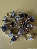 Photo showing assortment of rings laid flat on surface, highlighting various shapes and large faux gemstones