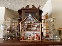Overview of wooden house shelf flanked by glass display cabinets with central wooden cabinet behind