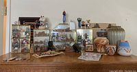 Overview of all Southwestern miniatures and pottery on wooden dresser with glass display cases and figurines