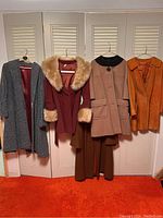 Overview of five hanging coats showing colors and styles