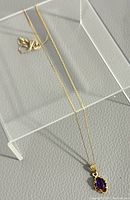 Full view of 17-inch gold chain and pendant on display stand