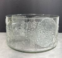 Side view of large clear glass bowl showing detailed embossed floral designs in the Flora pattern.