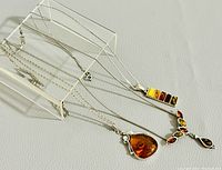 Both necklaces laid flat on neutral background showing chains and pendants.