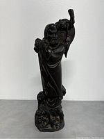 Front view of full figurine showing posture, fan and detailed base