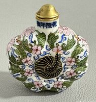 Front view showing hand painted gold and famille rose pumpkin design with floral and vine patterns