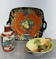 Front view of lot, showing Nippon bowl, decorative plate with fruit, and vintage Asian vase