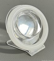 White jade bangle displayed on a clear acrylic stand showing its circular shape and polished finish.