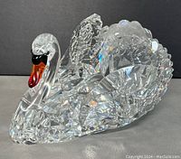 Three-quarter view of clear cut crystal swan figurine showing body and head details