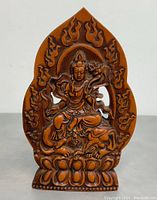 Front view showing seated Buddha with lotus base and flame motifs.