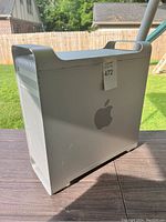 Side view showing the aluminum casing with Apple logo and handle on top for carrying.