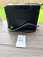 Full view of black CyberPower UPS backup battery supply unit showing the logo and vent on side with the power cord wrapped around it.