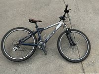 Photo of mountain bike showing full side profile on pavement, indicating bike make, model, and condition.