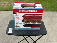 Box for George Foreman Evolve 4-in-1 grill showing product image and features, including 5 servings and removal of 45% of fat.